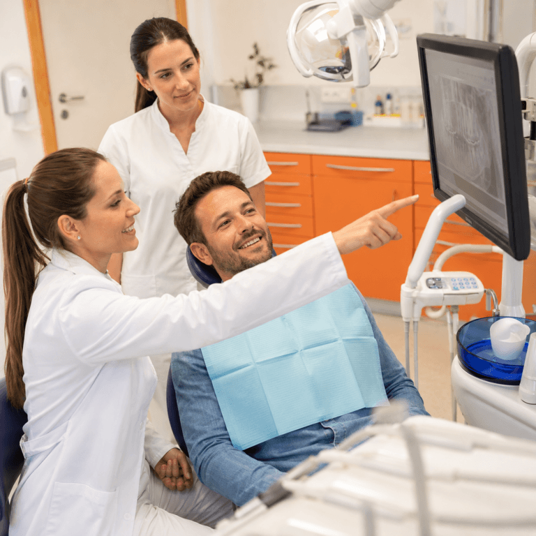Consulta dentária em clínica médica com paciente a observar radiografia digital
